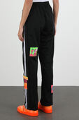 תמונת דוגמן אחורית של ג'רמי סקוט לאדידס מכנסי ג'וג עם פאצ'ים צבעוניים בצבע שחור
