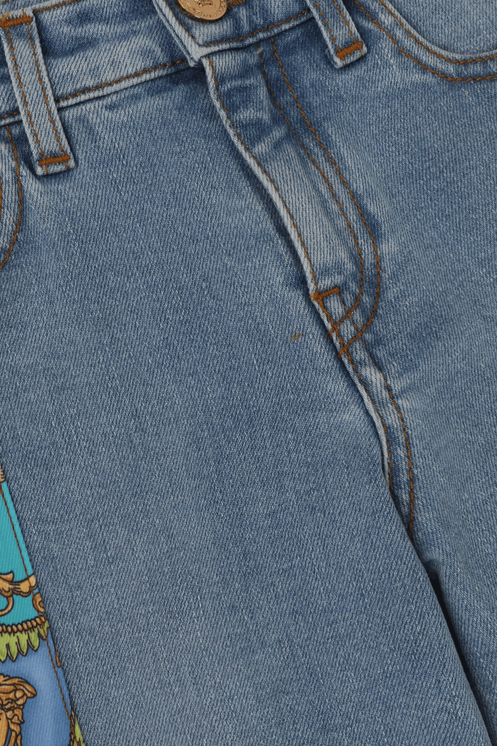 תמונת תקריב של גילאי 4-6 מכנסי ג'ינס מתרחבים עם פאץ' וינטג' צבעוני