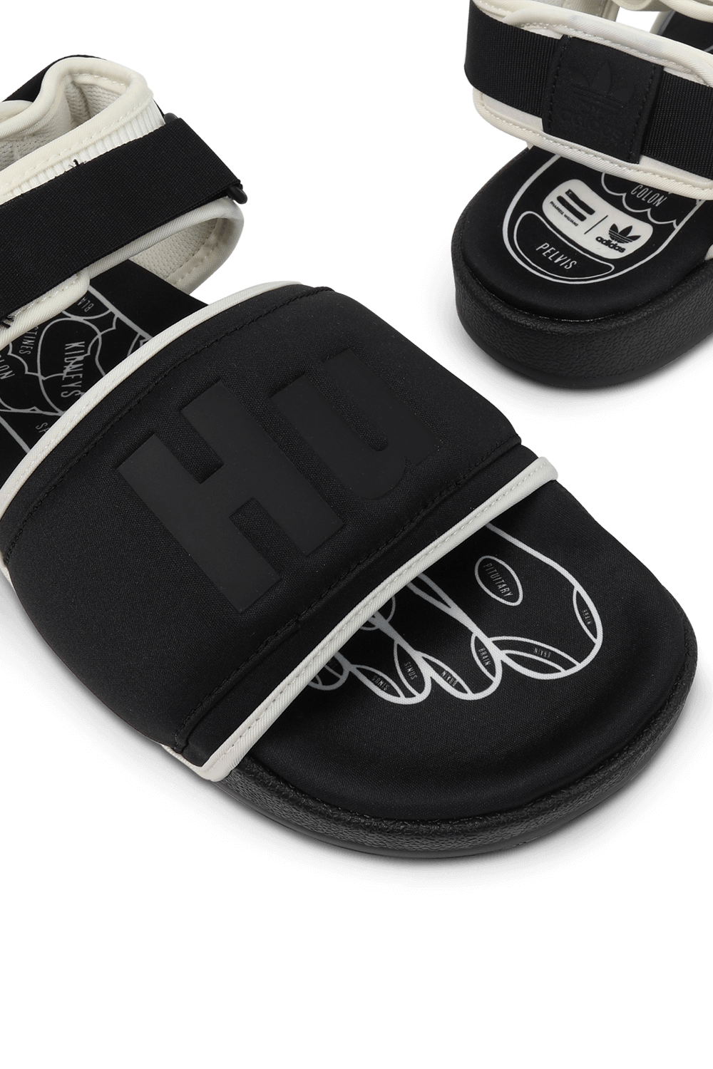 תמונת תקריב של אדידס עם פארל וויליאמס סנדלים בצבעי שחור ולבן