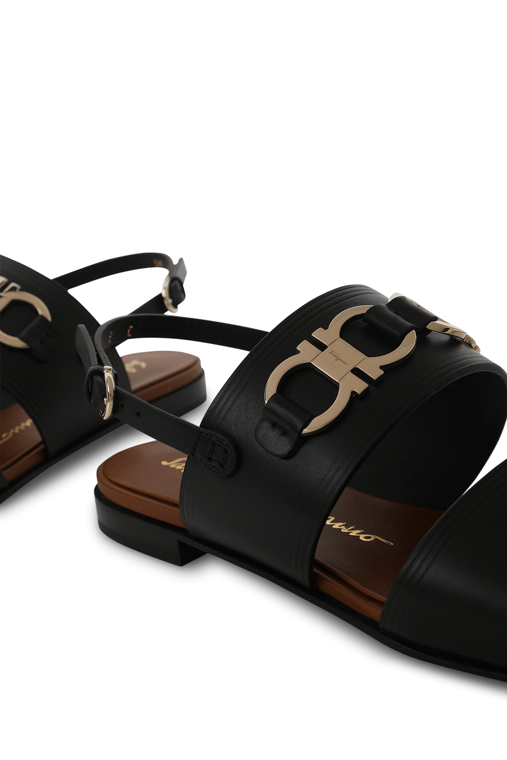 תמונת תקריב של סנדלים שחורים עם אלמנט מטאלי