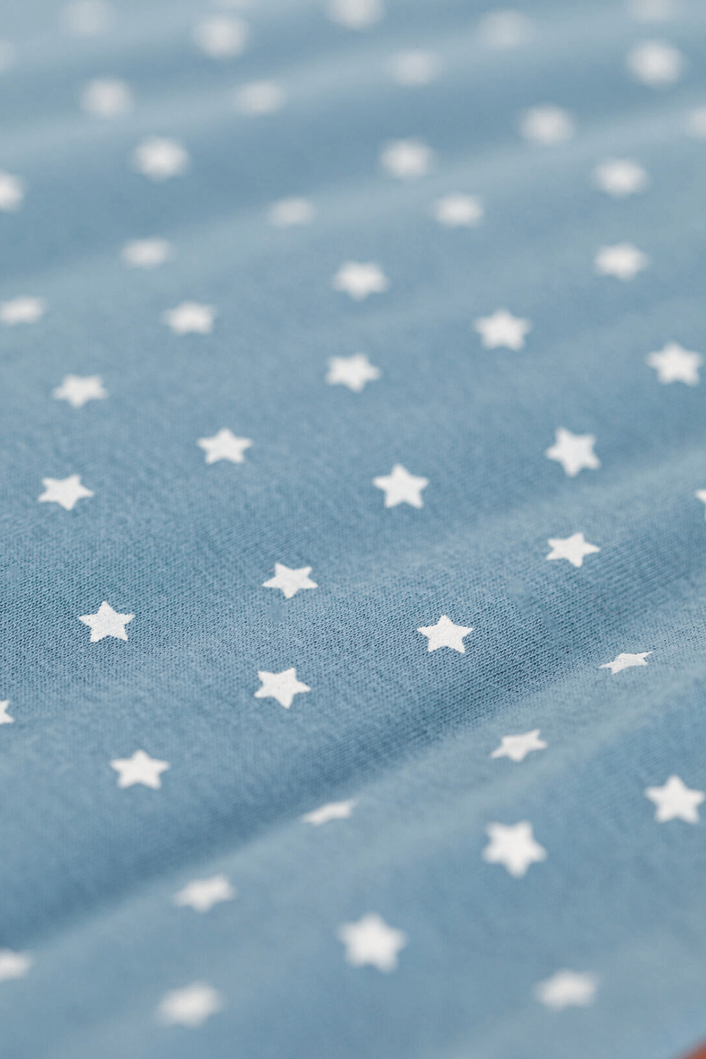 תמונת תקריב של שק שינה לבן בהדפס כוכבים עם סגירת רוכסן  -גיל  6 חודשים- 18 חודשים