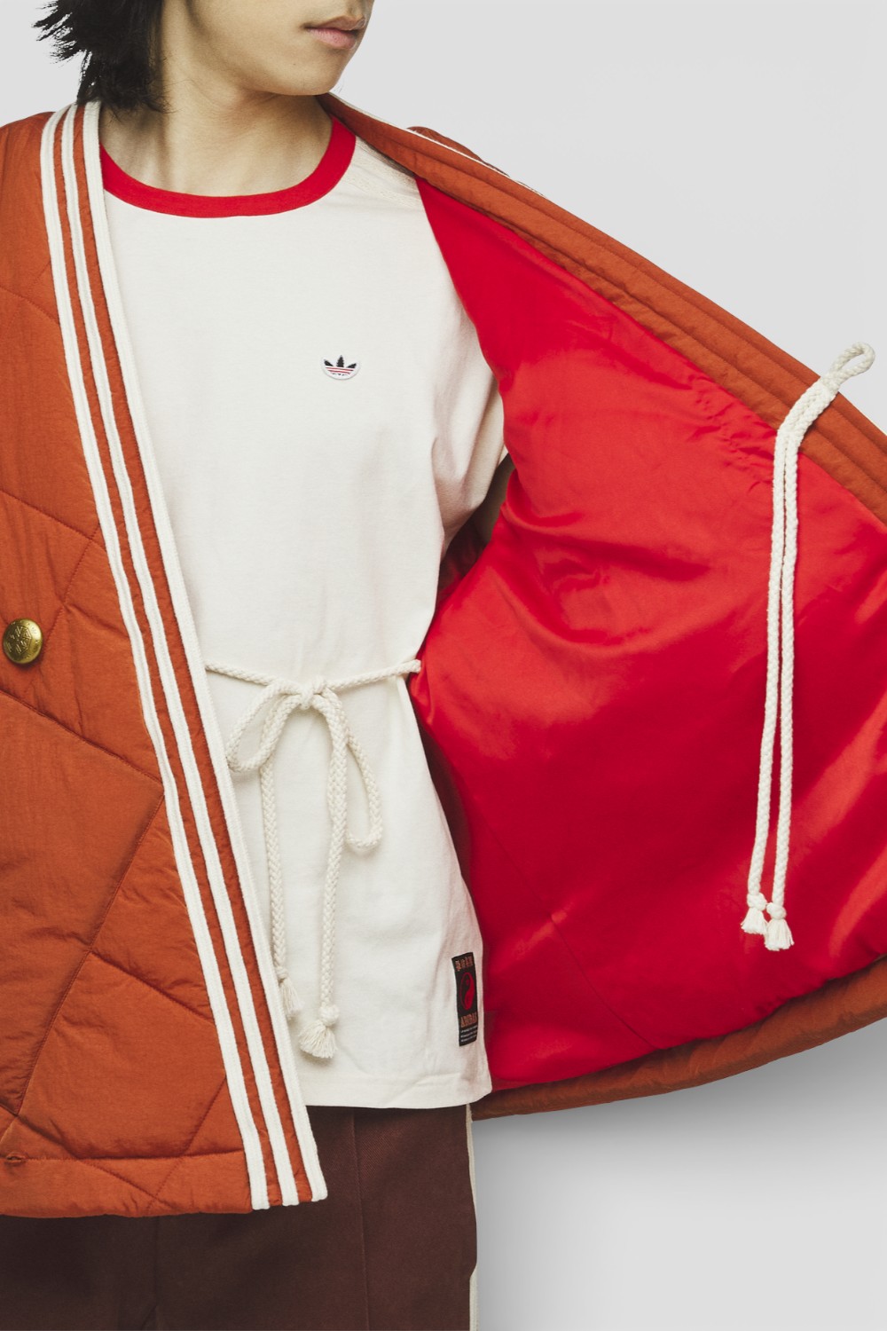 תמונת תקריב דוגמן של מעיל מעטפת אדיסון צ'אן x אדידס