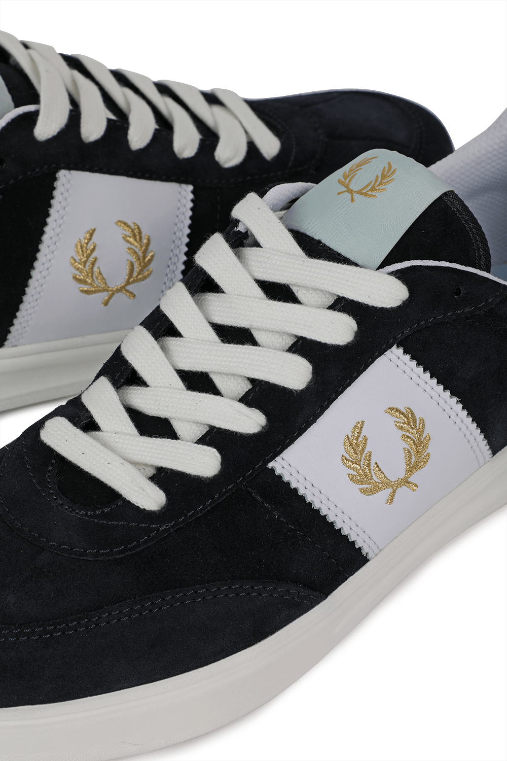 תמונת תקריב של נעלי סניקרס עם לוגו זהב רקום