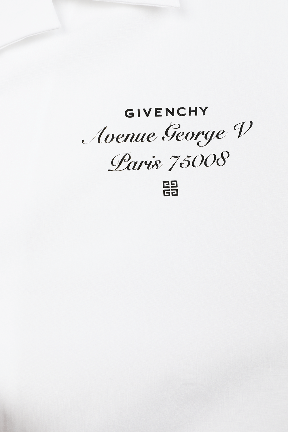 תמונת תקריב של חולצה מכופתרת קצרה לבנה עם כיתוב לוגו