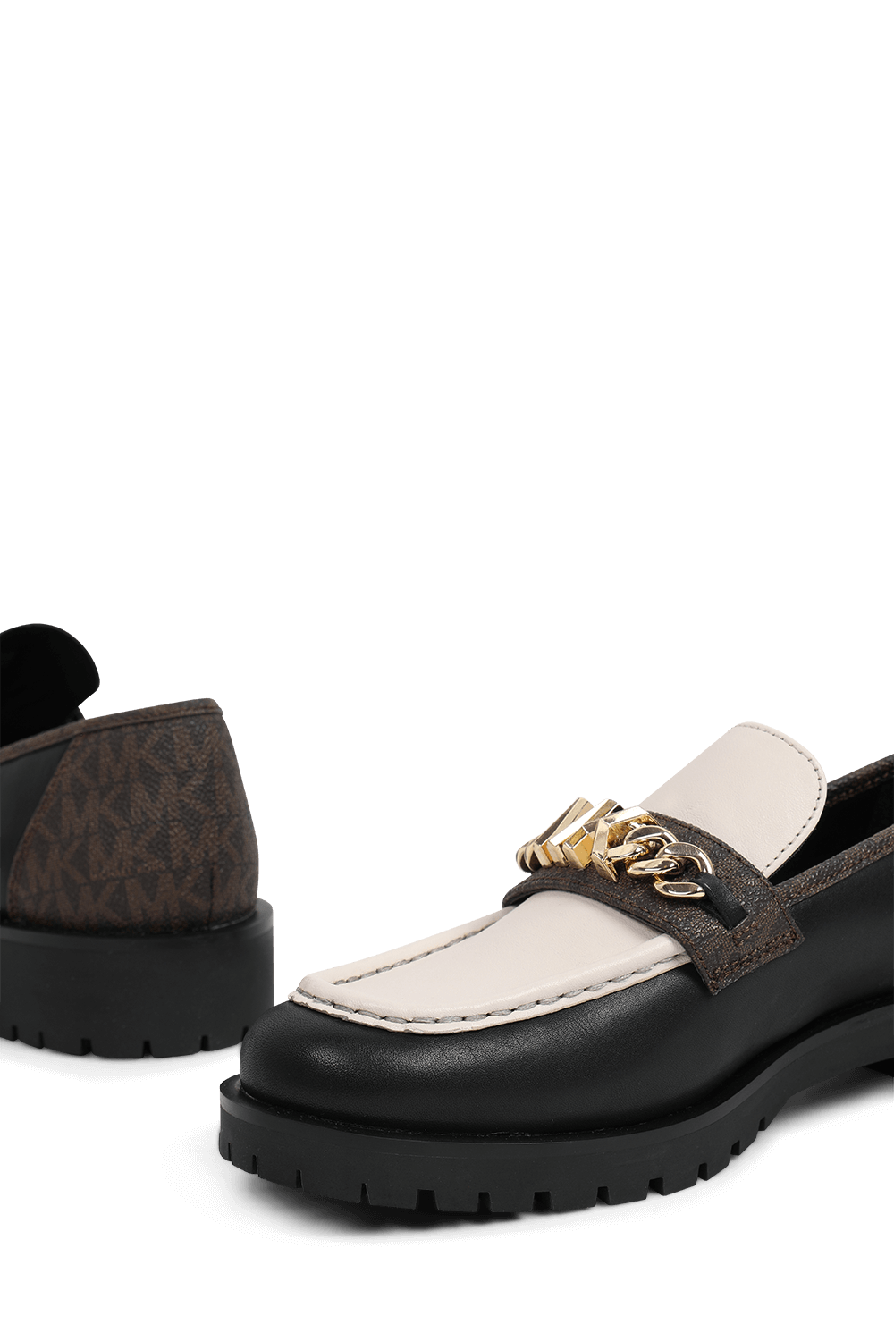 תמונת תקריב של נעלי מוקסינים מעור עם הדפס מונוגרמי בגווני חום ושמנת