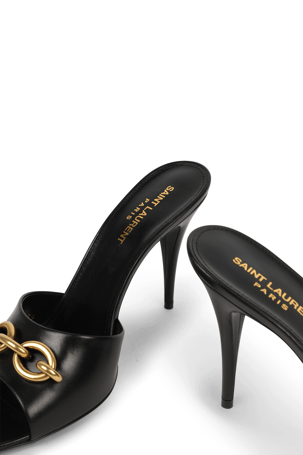 תמונת תקריב של נעלי עקב שחורים מעור עם אבזם זהב