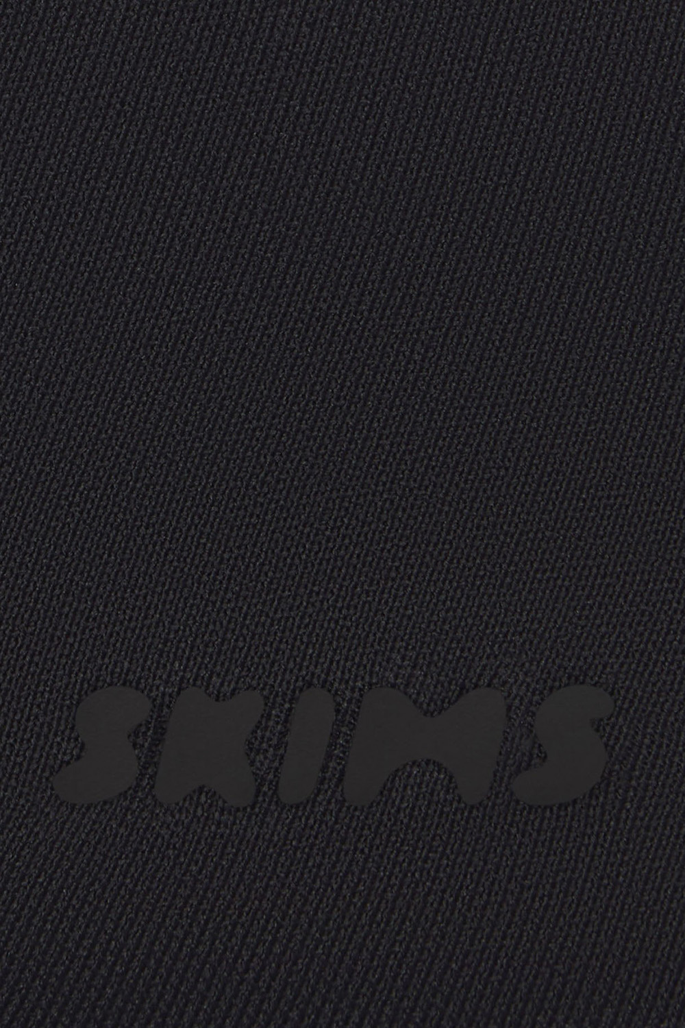 תמונת תקריב דוגמן של SKIMS ULTIMATE BODY THONG BODYSUIT