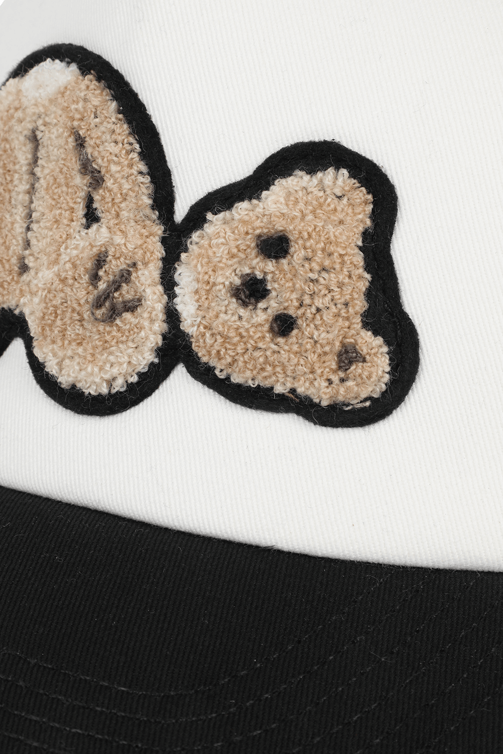 תמונת תקריב של כובע רשת עם דובי בגווני שחור ולבן