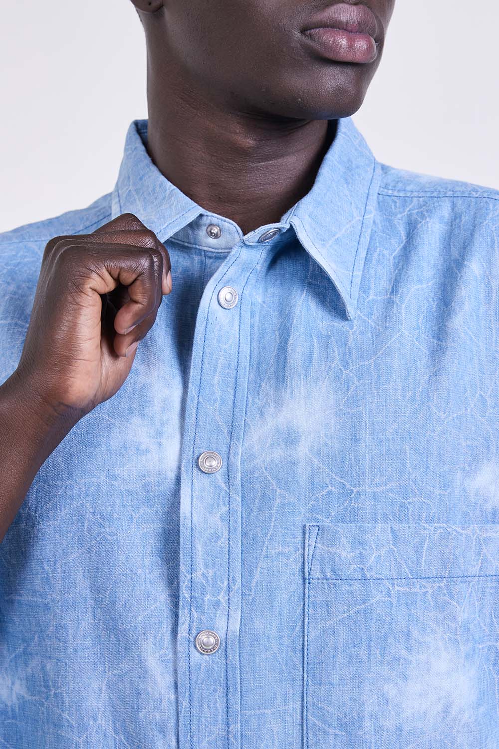 תמונת תקריב דוגמן של חולצה מכופתרת ג'ינס