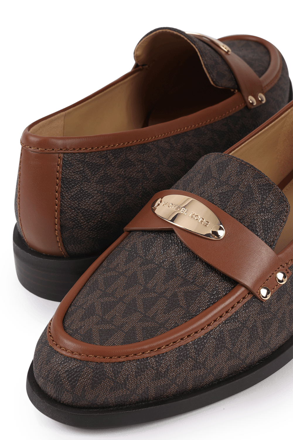 תמונת תקריב של נעלי מוקסין מונוגרמיות בגווני חום