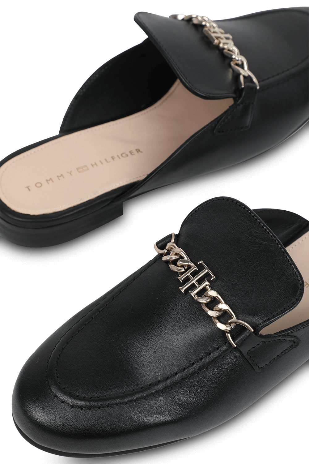 תמונת תקריב של כפכפי מיולס שחורים עם שרשרת מוזהבת