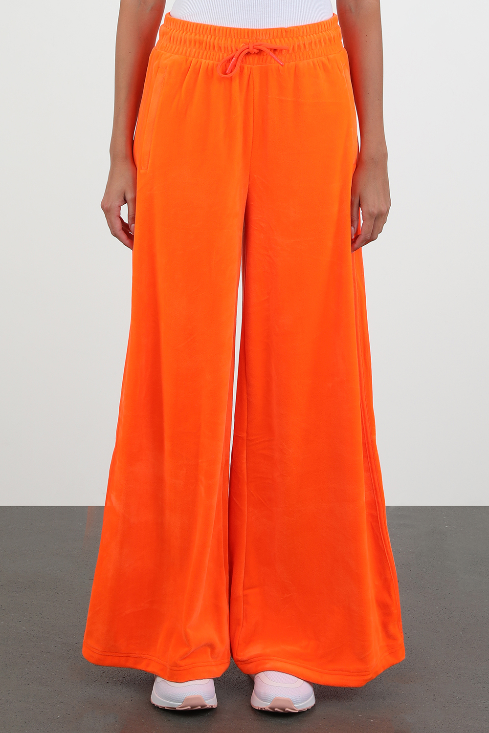 תמונת דוגמן קידמית של ג'רמי סקוט לאדידס מכנסי טרנינג מתרחבים בגוון כתום