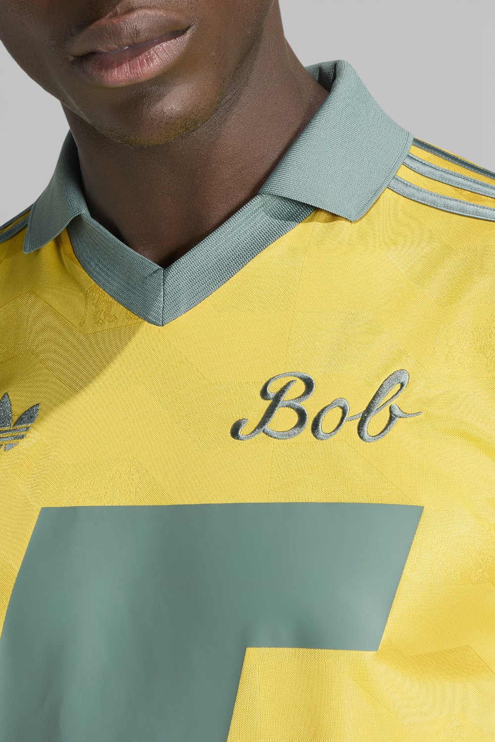 תמונת תקריב דוגמן של חולצת פולו כדורגל בוב מארלי X אדידס