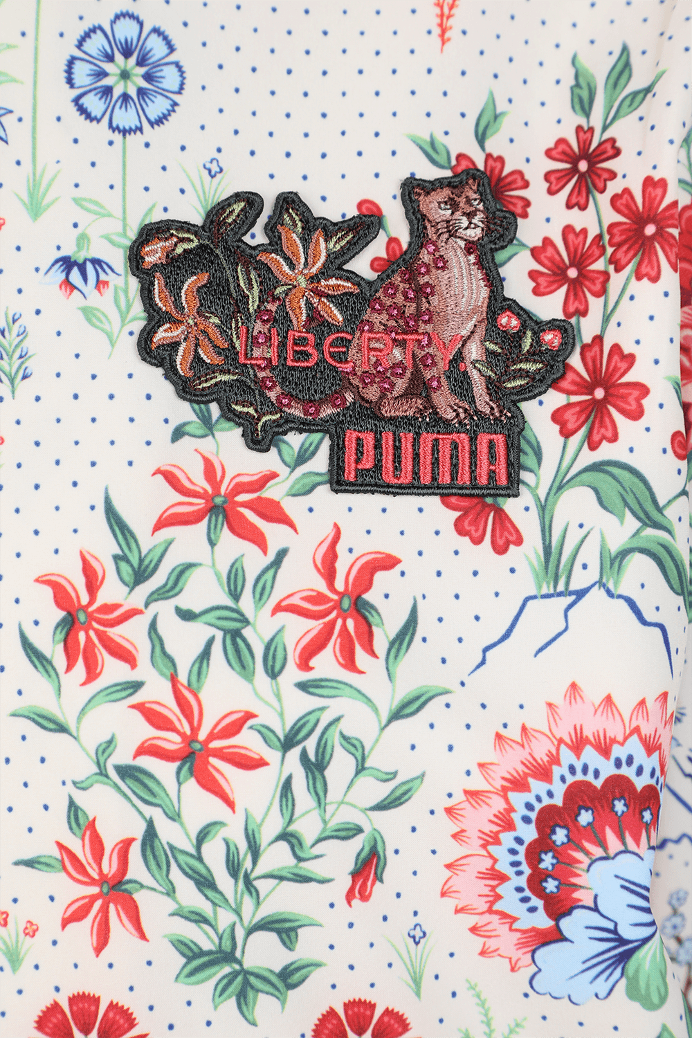 תמונה אחורית של פומה עם ליברטי ז'קט בומבר פרחוני על רקע לבן