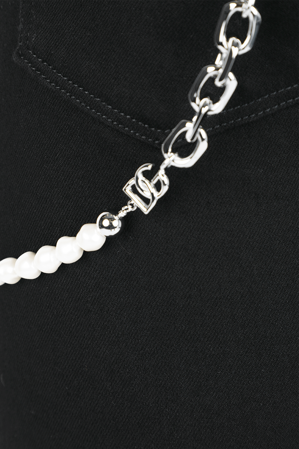 תמונת תקריב של מכנסיים בגזרת סקיני עם שרשרת כסופה בגוון שחור