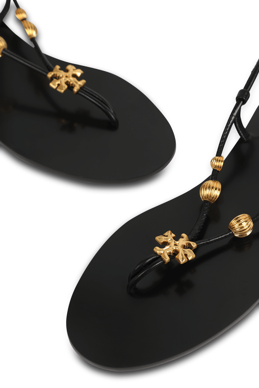 תמונת תקריב של סנדלים שחורים עם רצועת קרסול מתלפפת