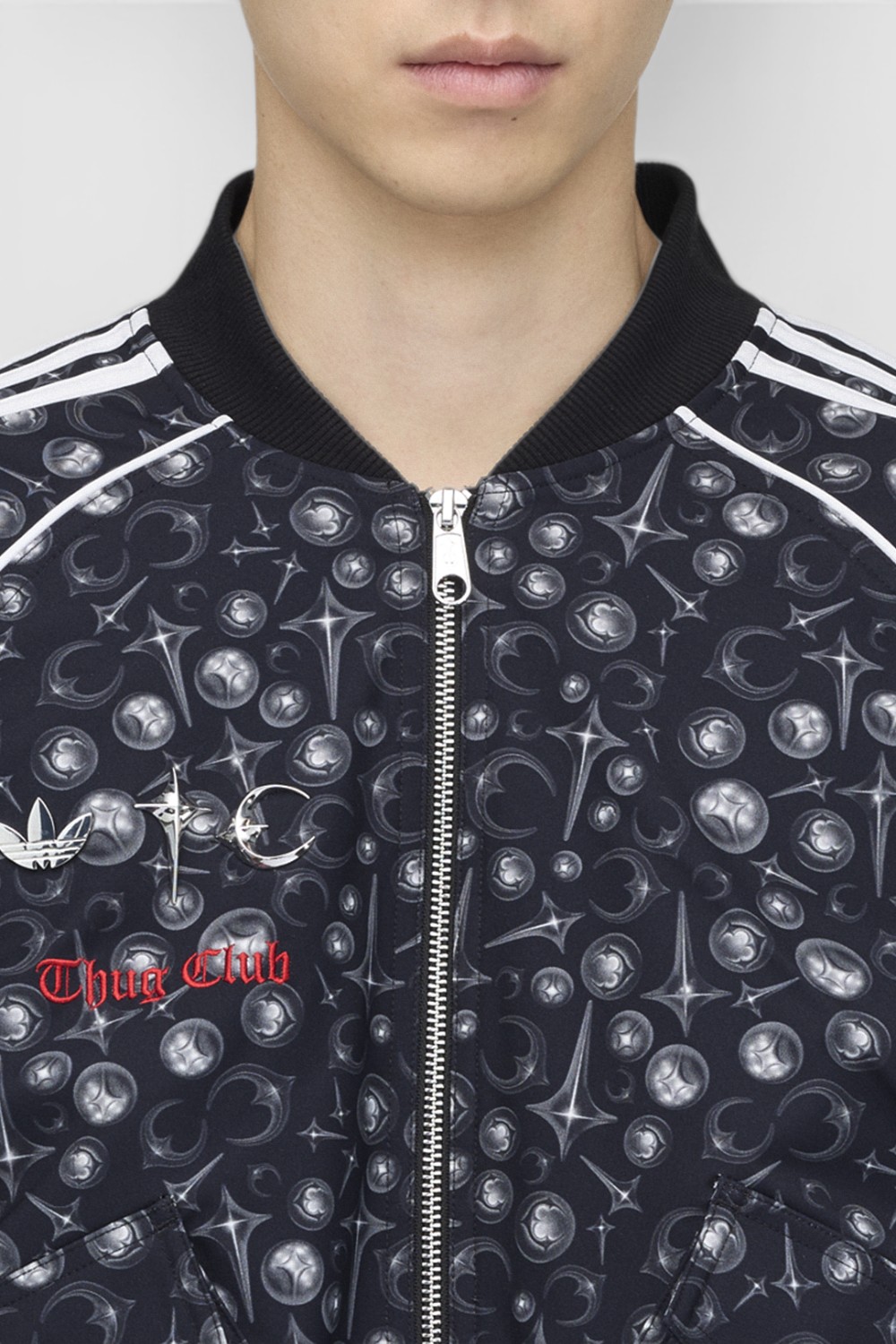 תמונת תקריב דוגמן של ז'קט טראק אדידס X ת'אג קלאב