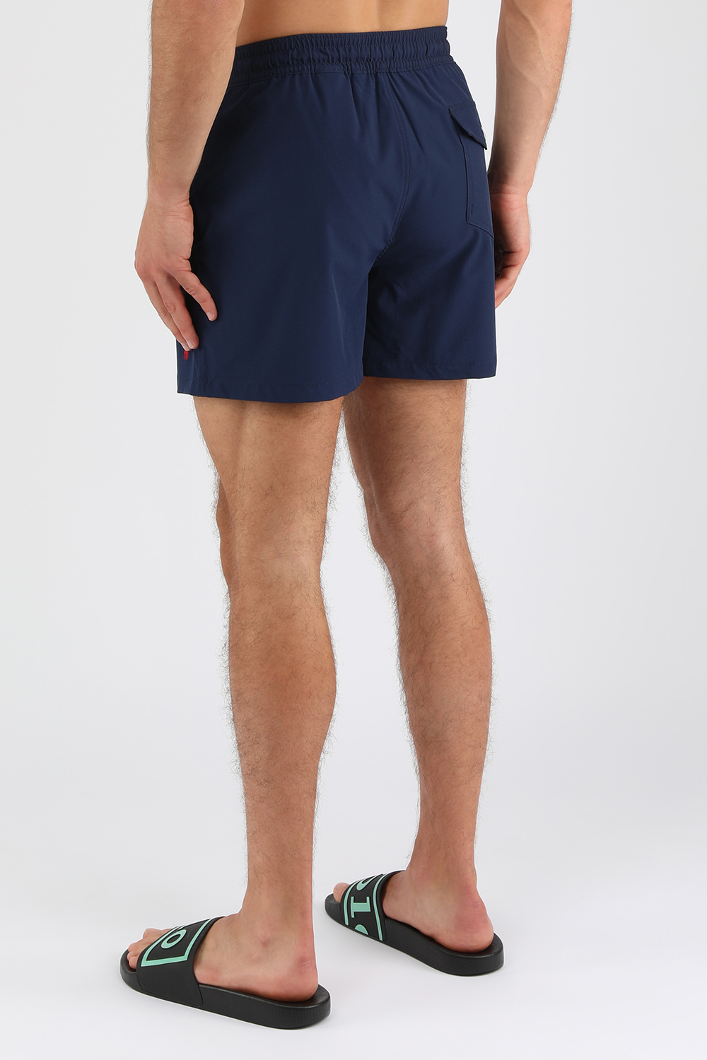 תמונת דוגמן אחורית של בגד ים קצר כחול עם לוגו רקום