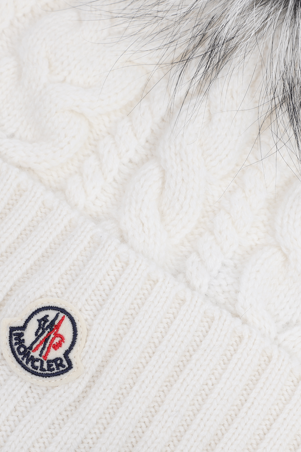 תמונת תקריב של כובע צמר עם פונפון פרוותי