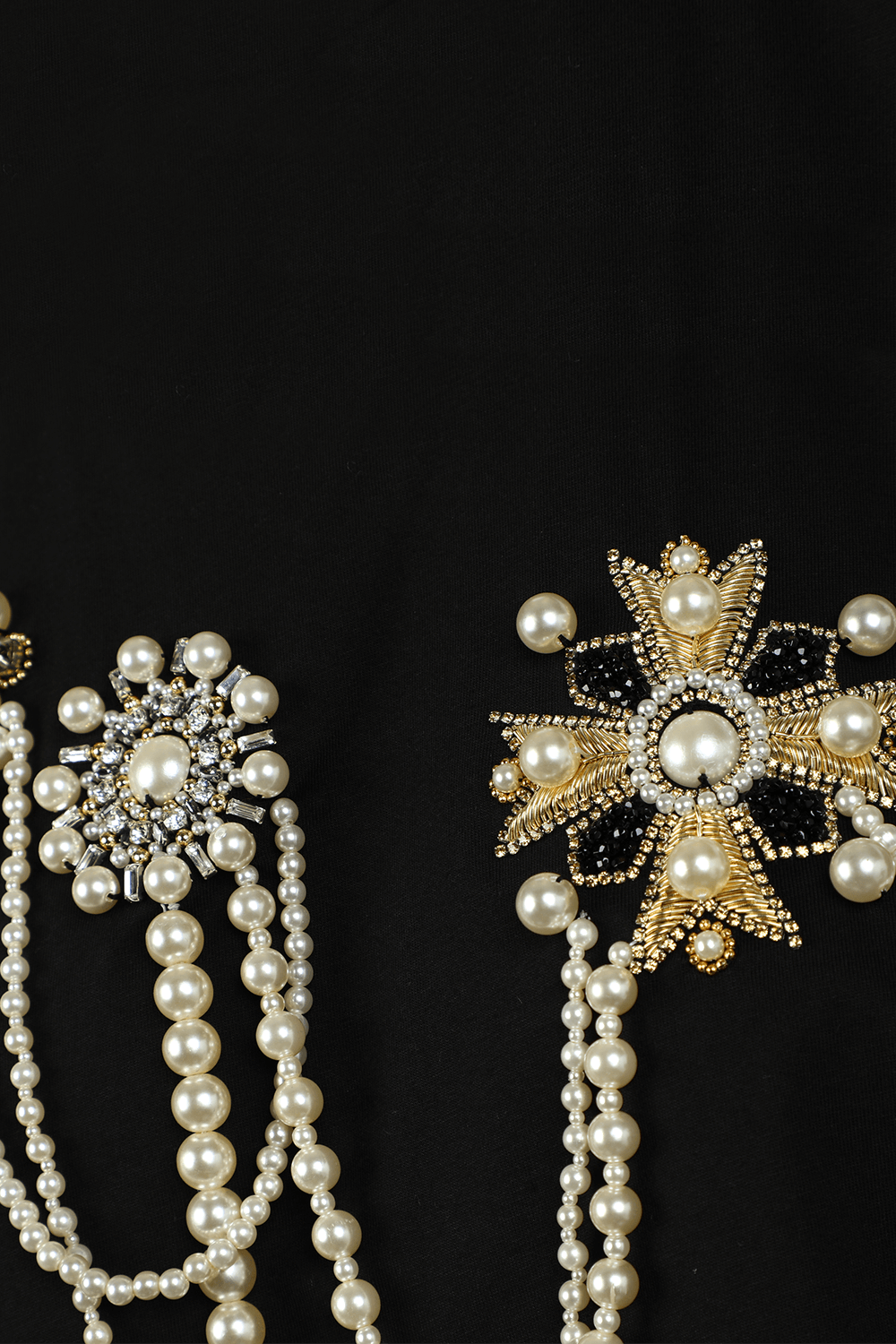 תמונה אחורית של חולצת טי קרופ עם שרשראות וסיכות פנינים