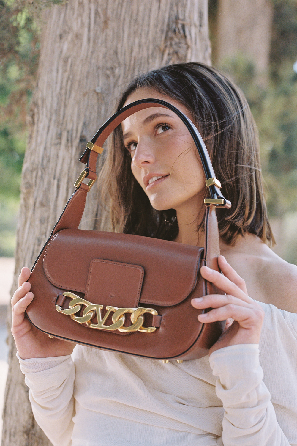 תמונת אווירה של תיק כתף מעור עם אבזם מונוגרמי