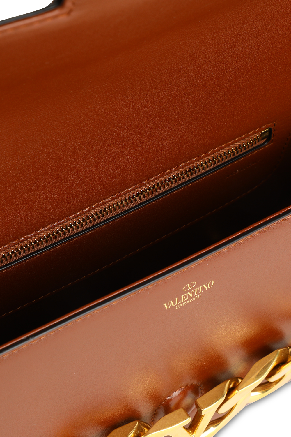 תמונת פנים של תיק כתף מעור עם אבזם מונוגרמי