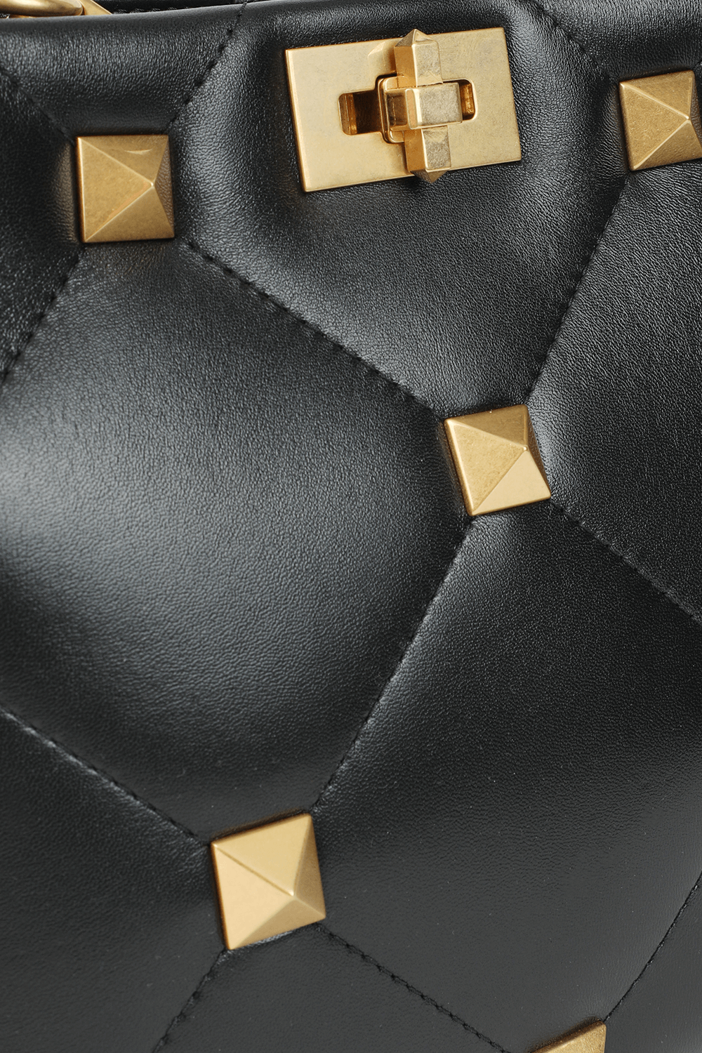 תמונת פנים של תיק נשיאה מעור שחור עם ניטים זהובים