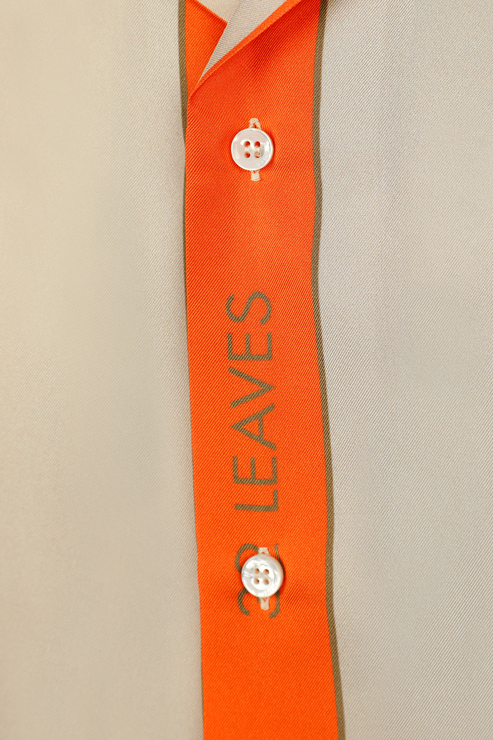 תמונה אחורית של חולצה מכופתרת קצרה בגווני בז' וכתום עם הדפס