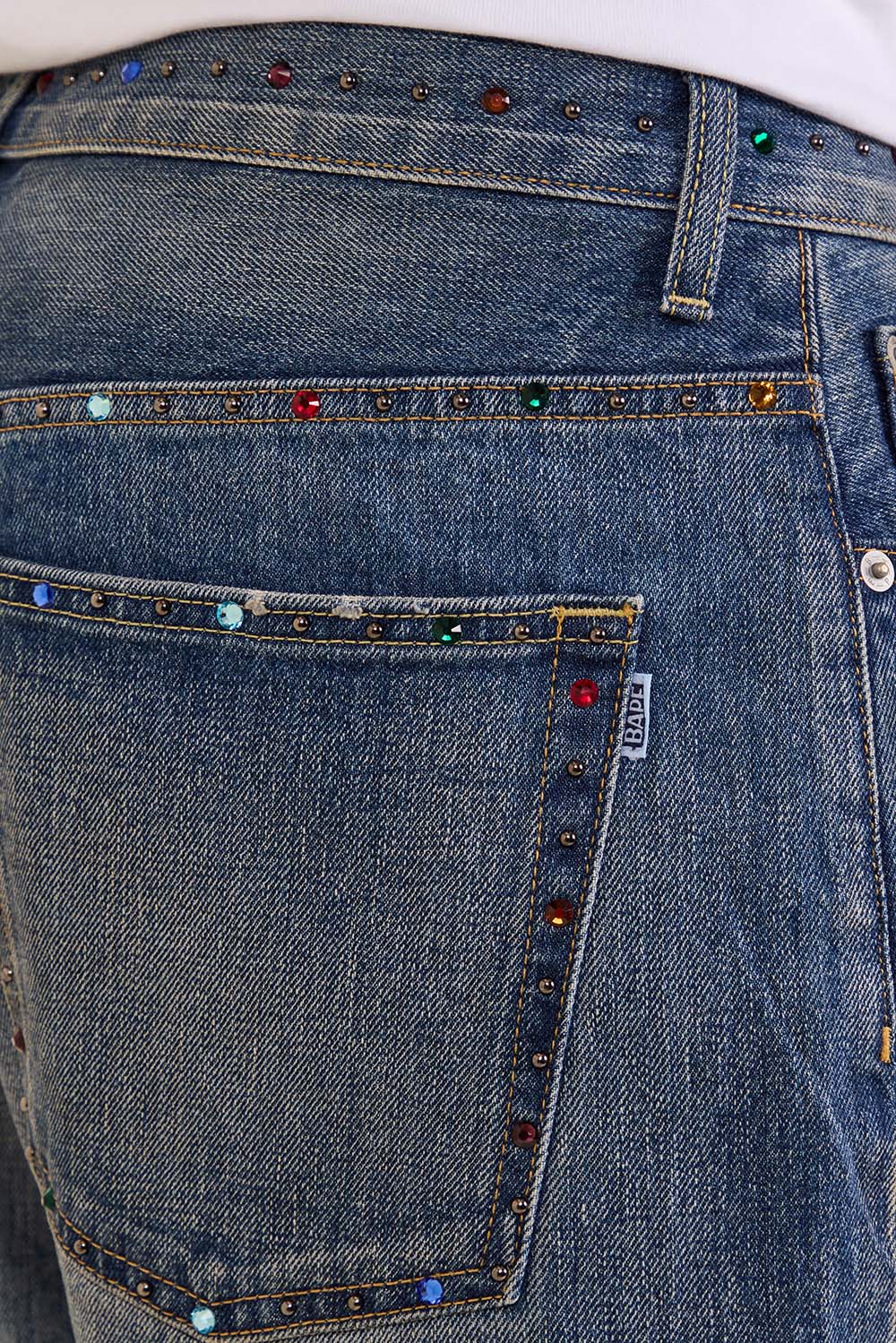 תמונת תקריב דוגמן של מכנסי ג'ינס בגזרה ישרה בשיבוץ אבנים