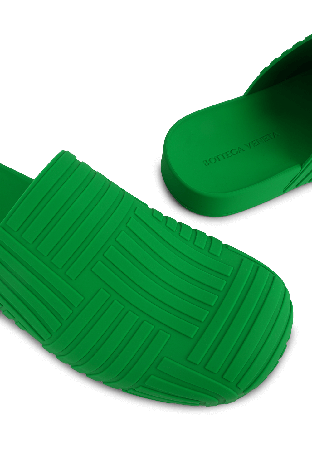 תמונת תקריב של סנדלי סליידס מגומי עם טקסטורה אייקונית