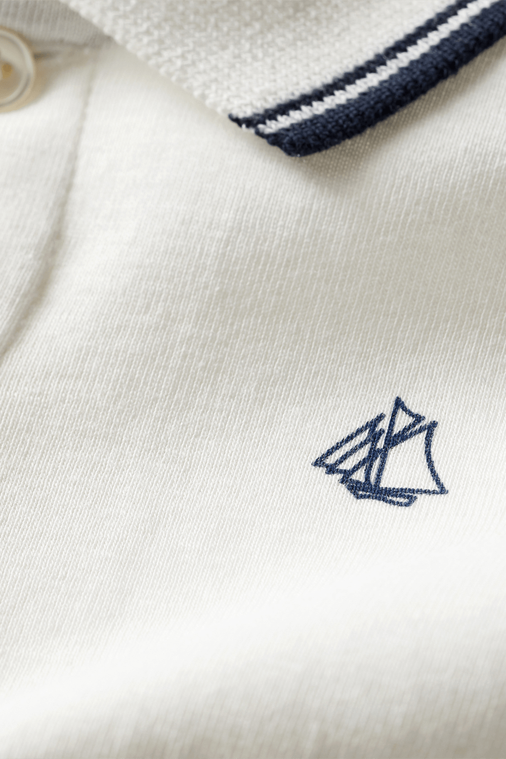 תמונת תקריב של חולצת פולו עם רקמת לוגו - גילאי 6-12 חודשים