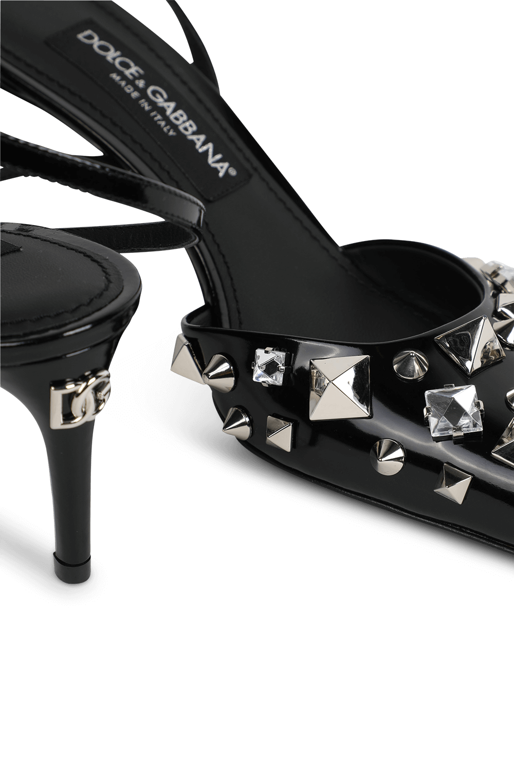 תמונת תקריב של סנדלי עקב נמוכים מעור עם עיטורי ניטים