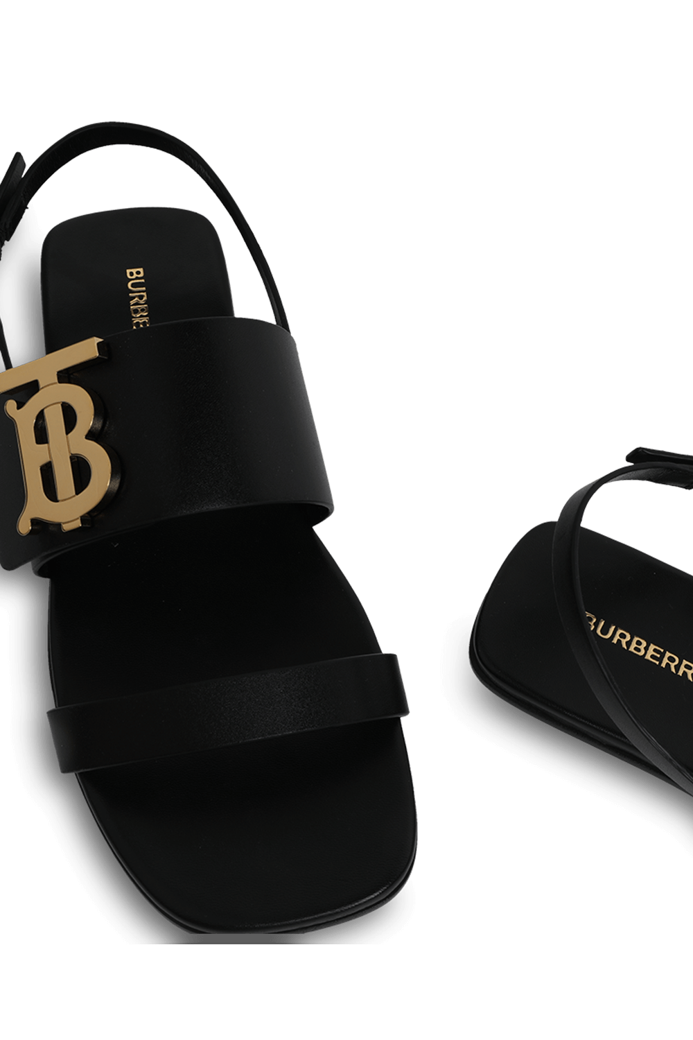 תמונת תקריב של סנדל שחור מעור עם אלמנט מוזהב