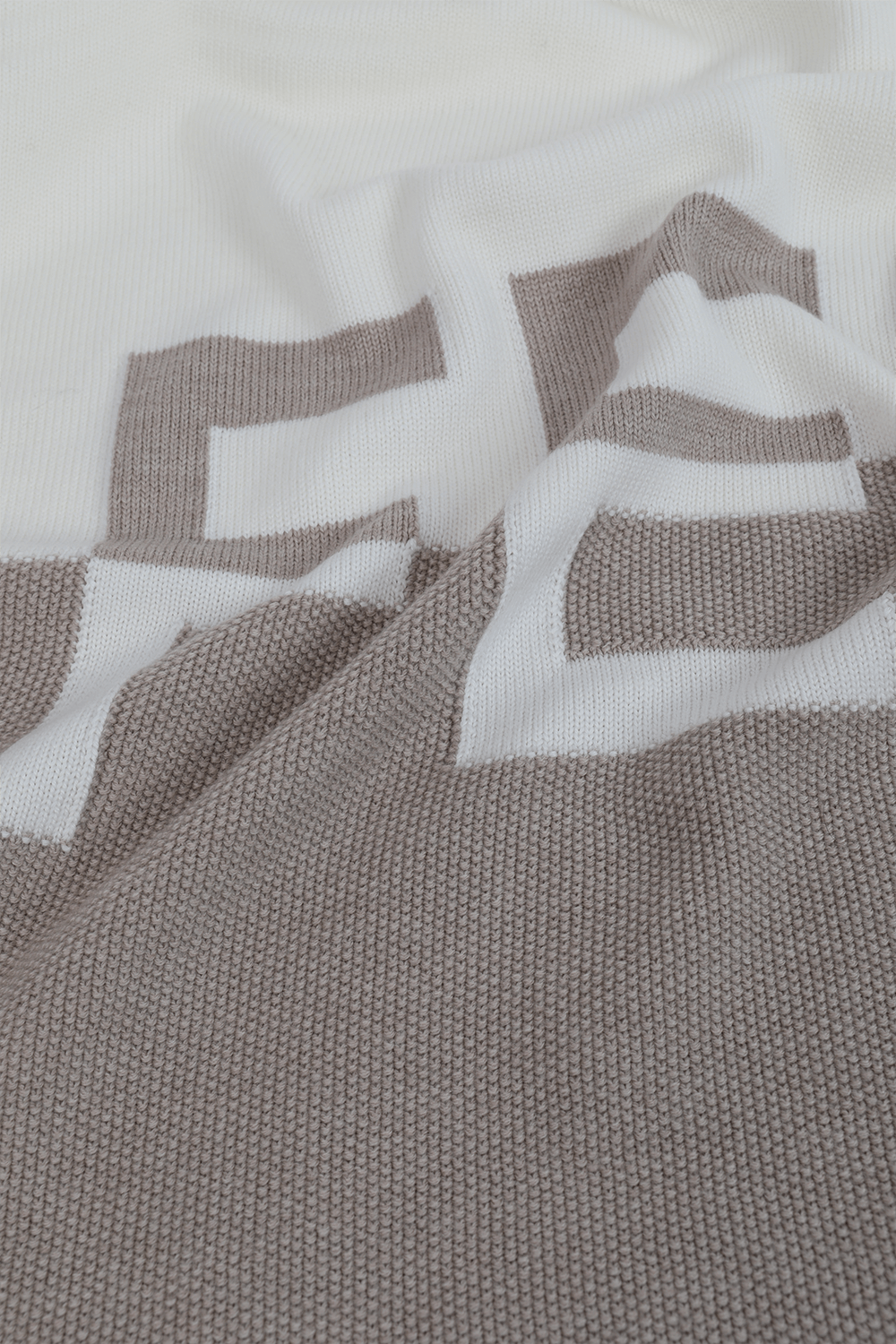 תמונה אחורית של שמיכת קשמיר עם לוגו בגוני שמנת ואפור