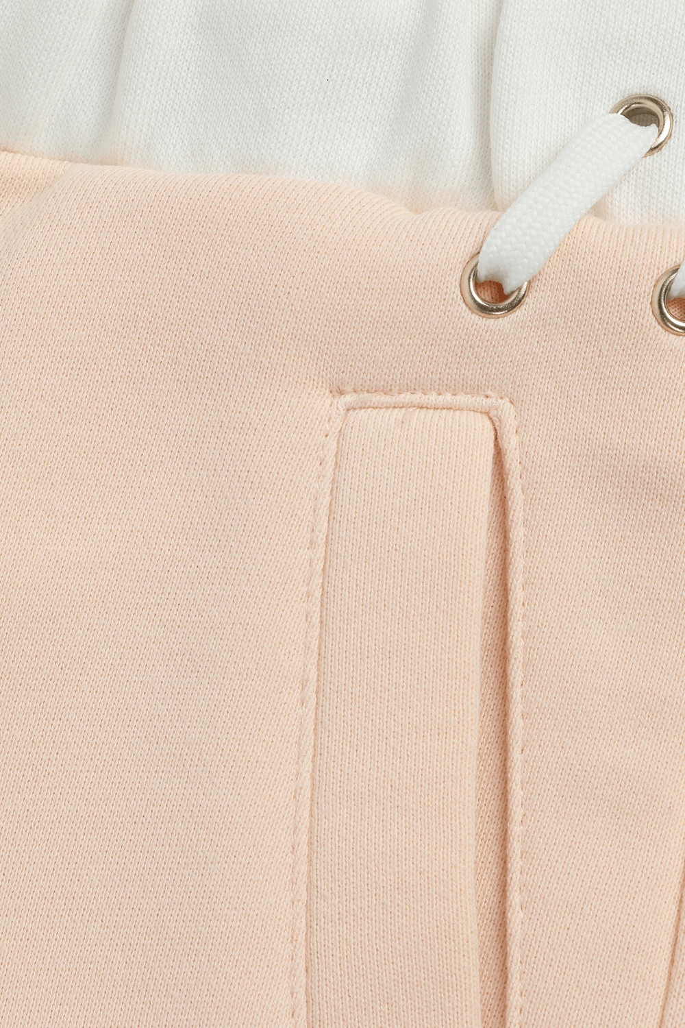 תמונת תקריב של גילאי 2-5 מכנסיים ורודים עם שרוכים לבנים