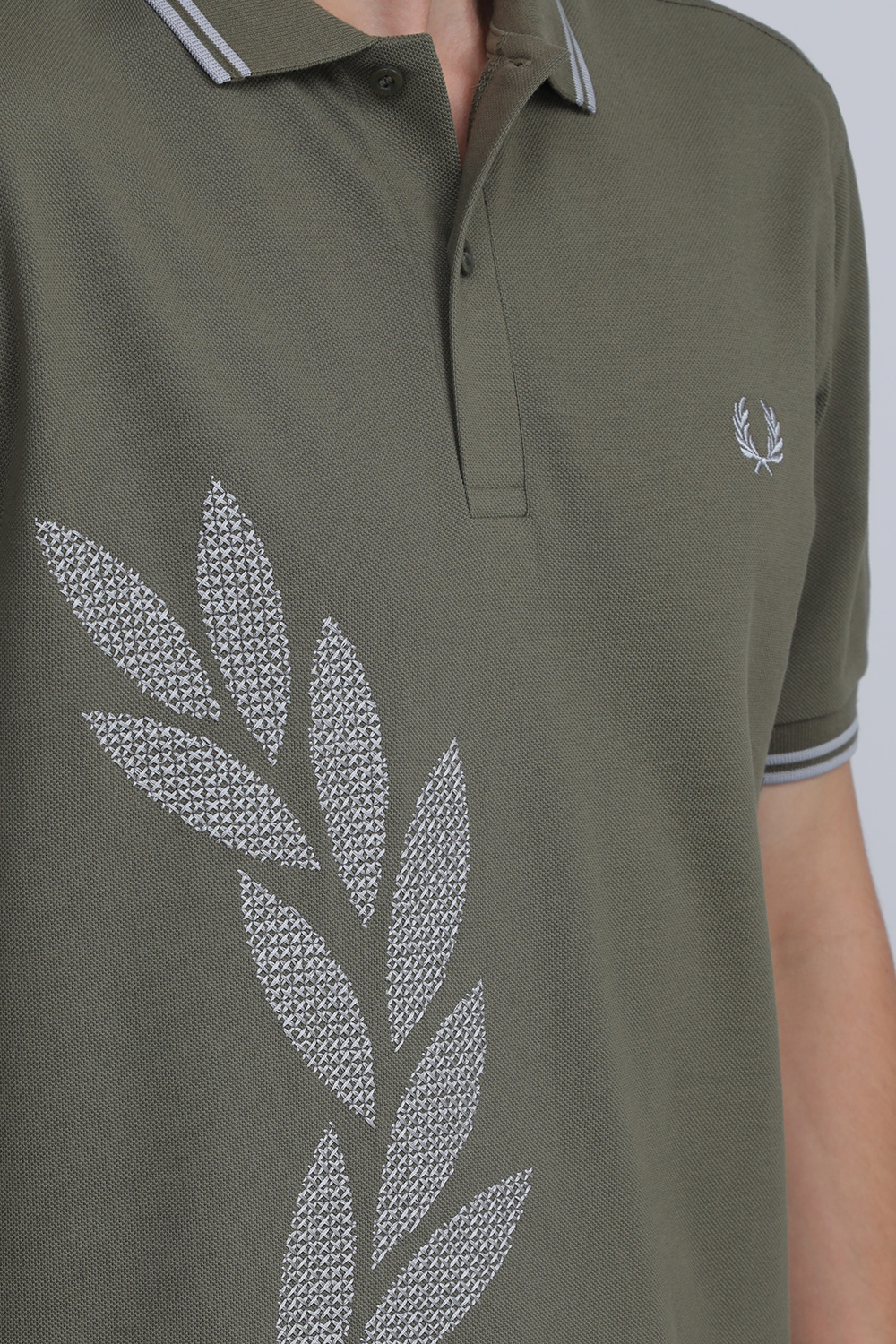 תמונת תקריב דוגמן של חולצת פולו עם רקמת איקס