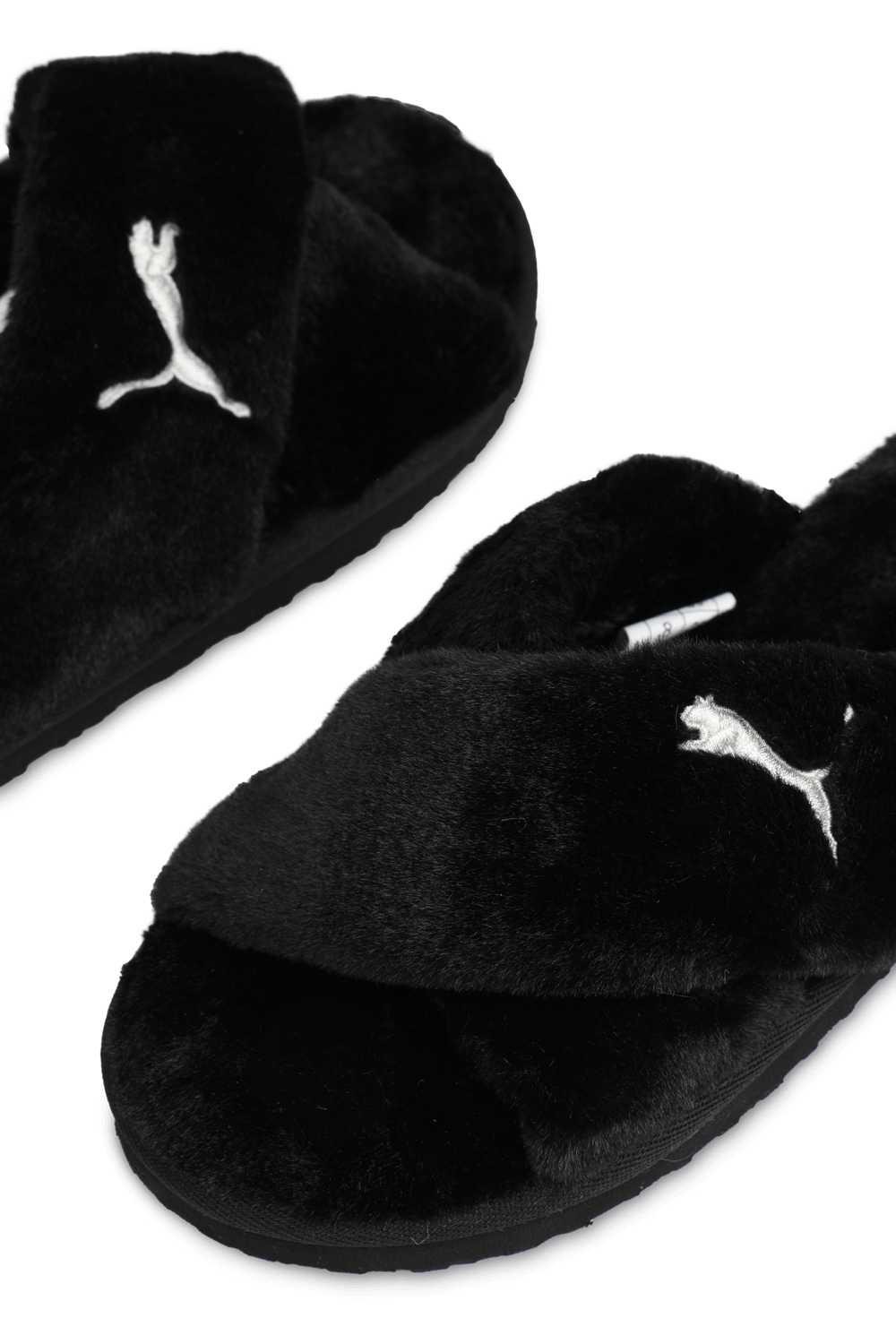 תמונת תקריב של כפכפים דמוי פרווה עם רצועות מצטלבות בגוון שחור