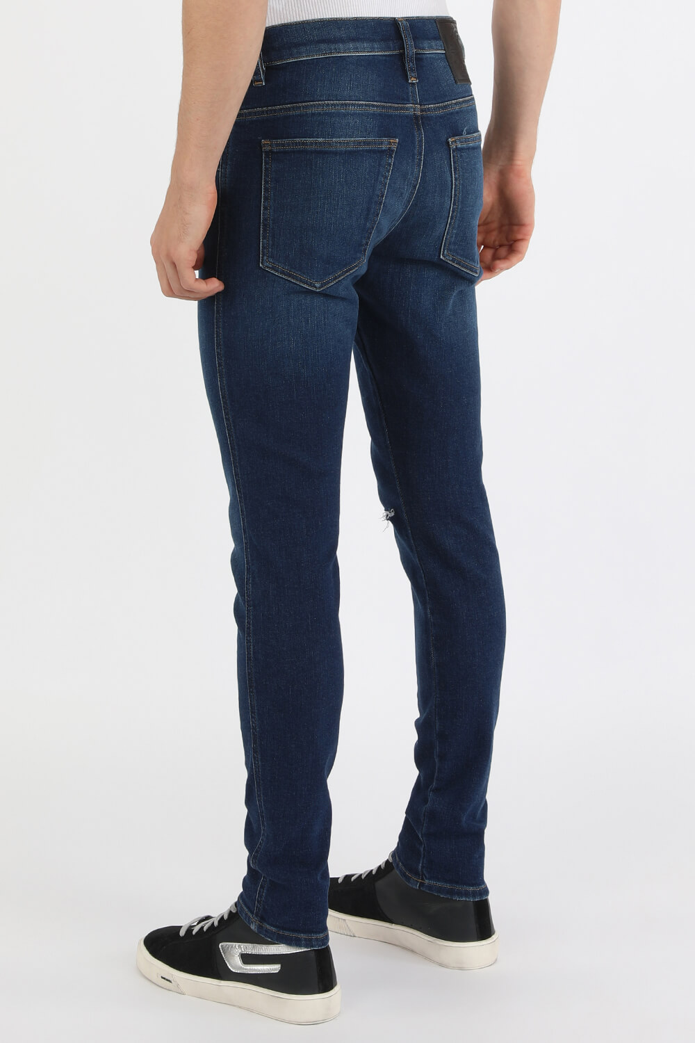 תמונת דוגמן אחורית של מכנסי סקיני ג'ינס עם קרעים בשטיפת אינדיגו