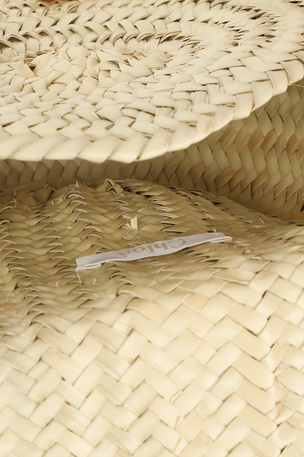 תמונת פנים של תיק קש עם פפיון לבן