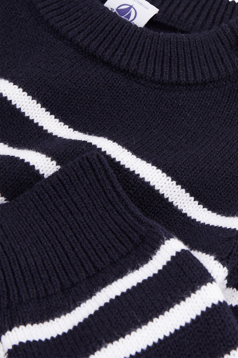 תמונת תקריב של גילאי 6-12 סוודר כחול עם וכפתורים