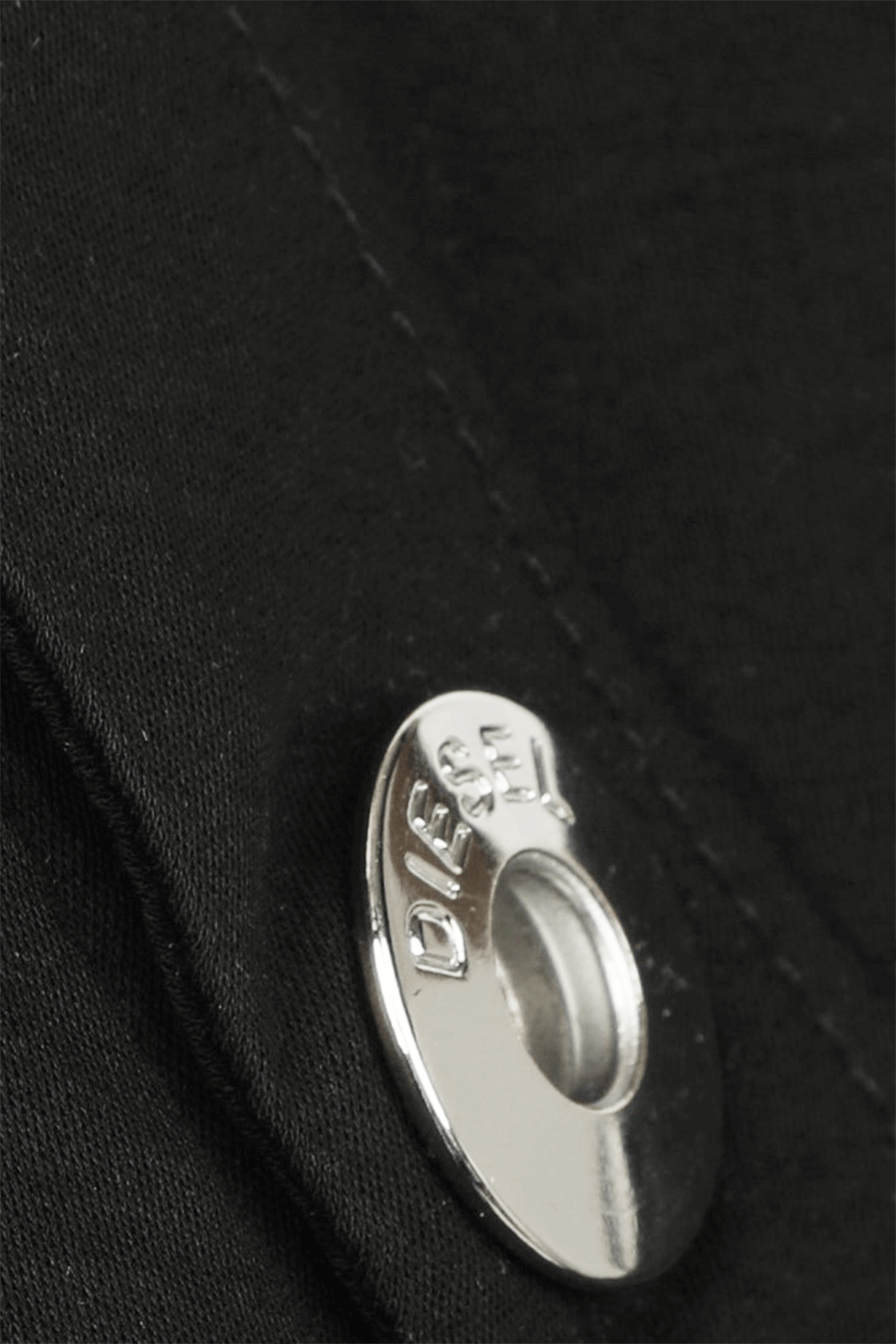 תמונת תקריב של חולצת טי שחורה עם כפתורים כסופים