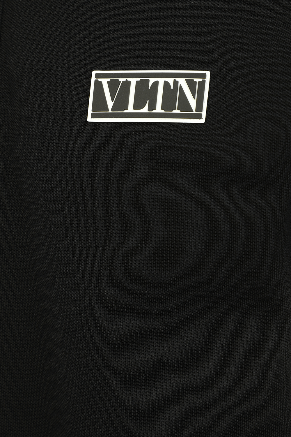 תמונה אחורית של חולצת פולו שחורה עם לוגו מכותנה