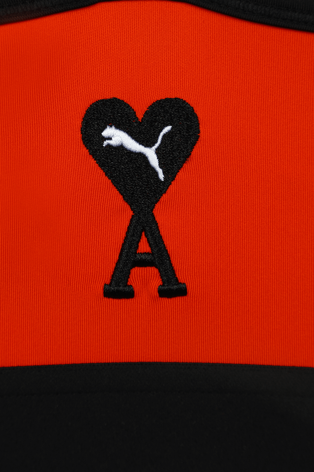 תמונת תקריב של פומה X אמי הודי חזיית אימון בגווני שחור וכתום