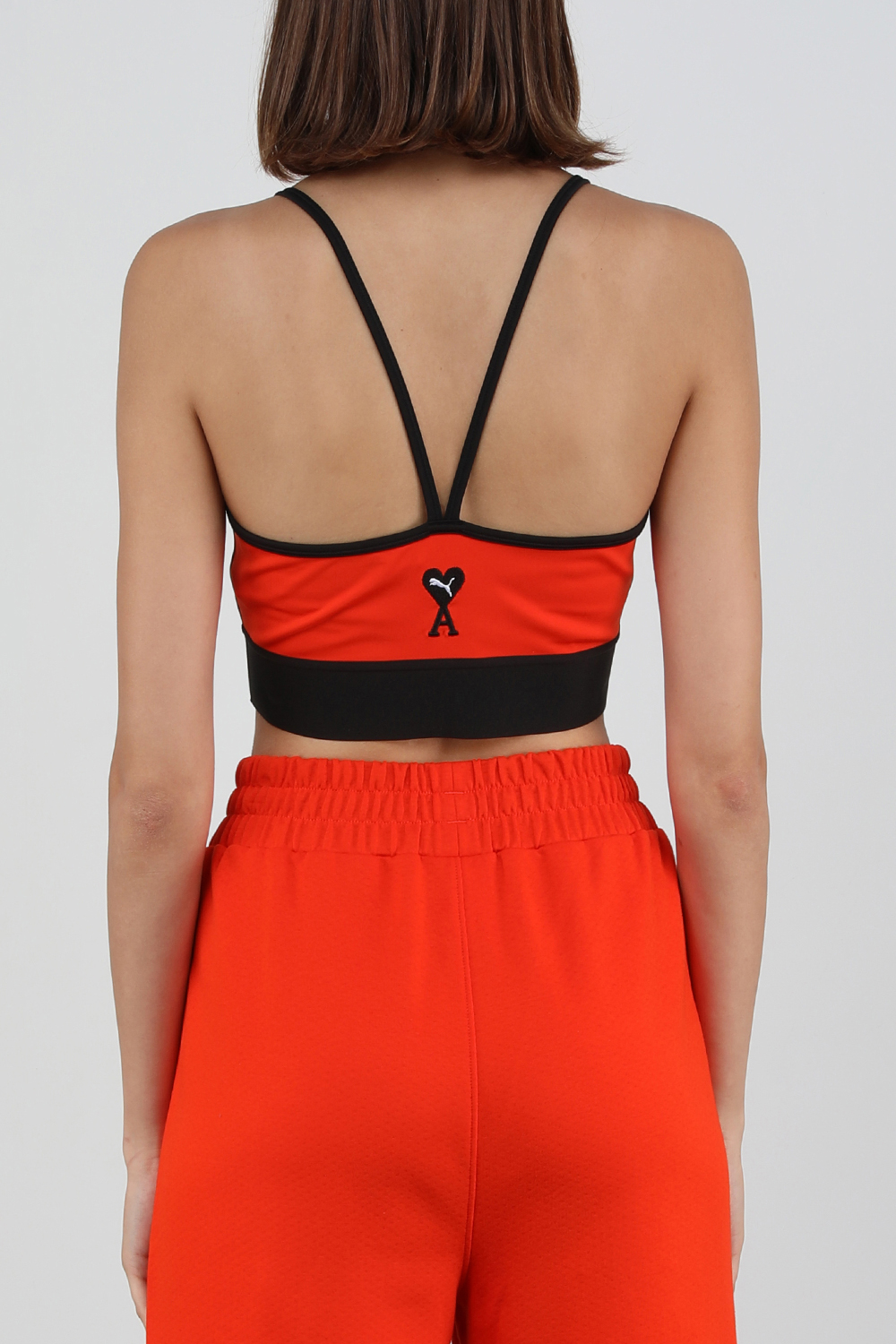 תמונת דוגמן אחורית של פומה X אמי הודי חזיית אימון בגווני שחור וכתום