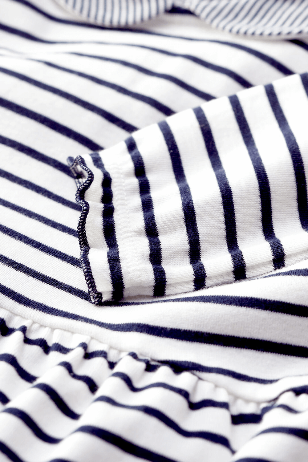 תמונת תקריב של גילאי 18-36 חודשים שמלת פסים כחולים על רקע לבן-מרשמלו עם צווארון פיטר פן