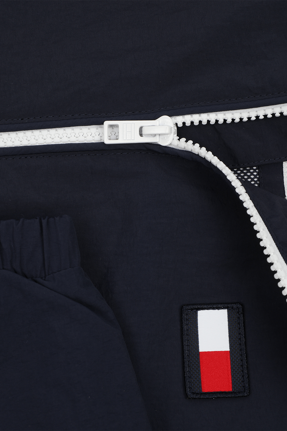 תמונת תקריב של גילאי 4-6 קולור בלוק ז'קט כחול עם דגל המותג